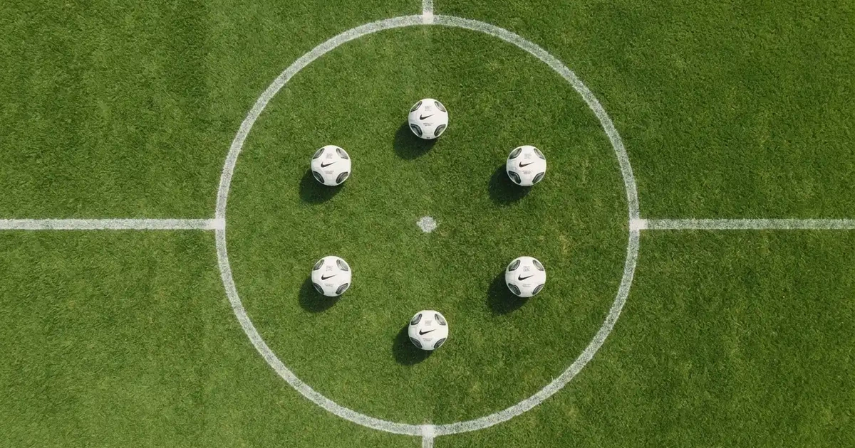 Sechs Fußbälle in einem Kreis auf einem gepflegten Rasen, von oben aufgenommen, gleichmäßiges Tageslicht.